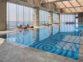 Una piscina techada, sillones reclinables de piscina