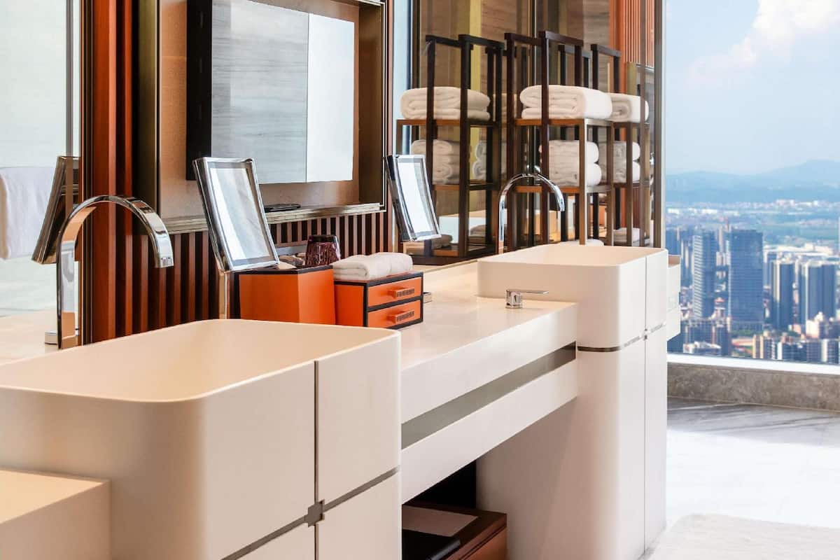 Een moderne badkamer met dubbele wastafels, een grote spiegel en een handdoekrek.