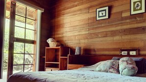 A wooden room with a bed, a window, and a shelf with items. - Best immersion experience in a Farm at Finca Queveri (Orosi)