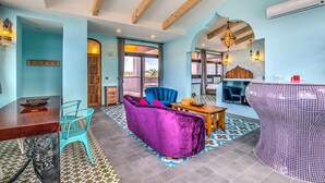 A spacious living area with a wooden dining table, a purple sofa, and a patterned rug. - Wien Art Villa (Liuqiu)