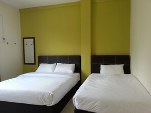 Two single beds with black headboards in a room with yellow walls. - Hotel Alor Villa (Alor Gajah)
