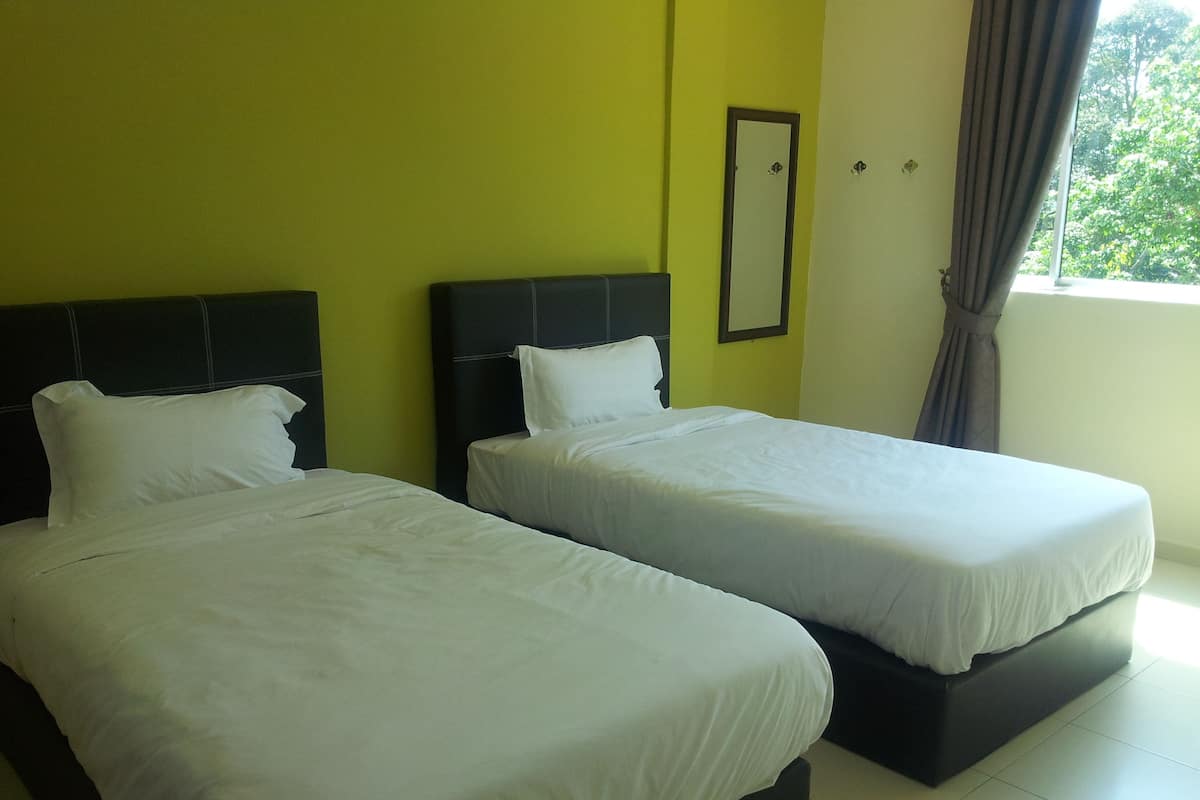 A hotel room with two beds, a large window with curtains, and a mirror on the wall.
