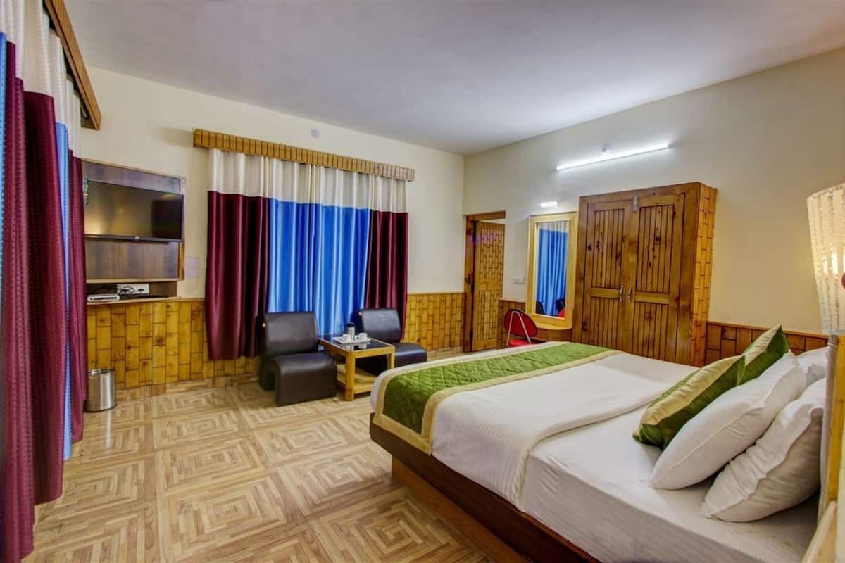 Una habitación de hotel con cama, televisión, escritorio y silla.
