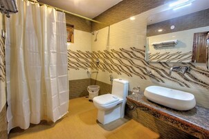 Ein Badezimmer mit Dusche, Toilette und Waschbecken, mit einer gemusterten Wand und Holzelementen.