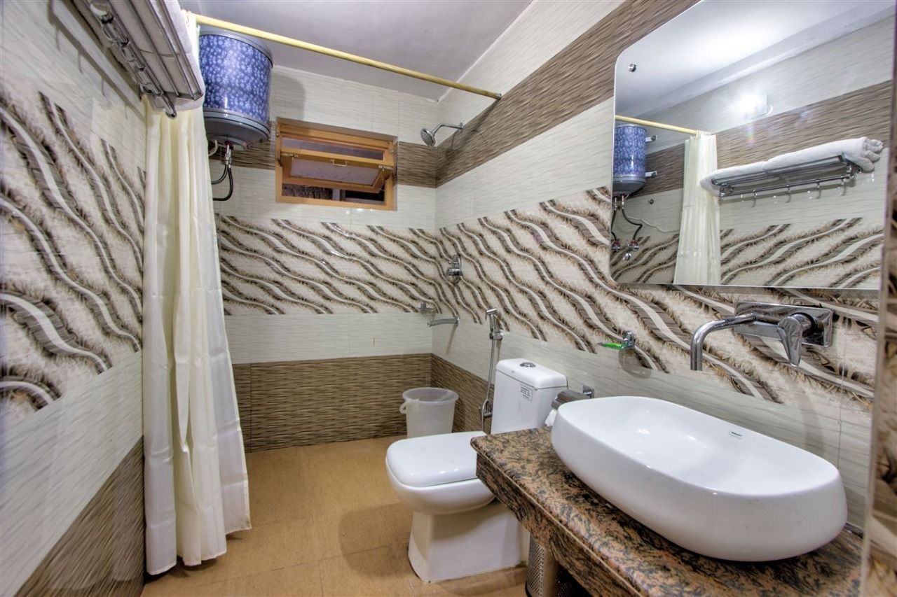 Une salle de bain comprenant des toilettes, un lavabo et un espace douche.