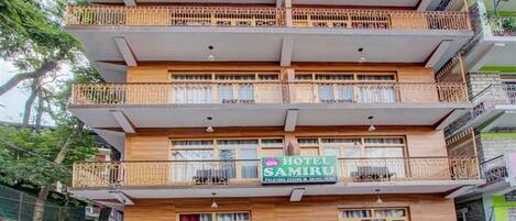 A multi-story building with a sign for "Hotel Samiru" on the ground floor.