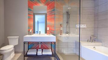 Een moderne badkamer met een witte wastafel, een douche met glazen wanden en een grote spiegel.