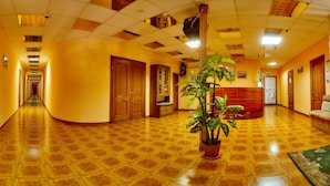 A hotel lobby with a checkered floor, wooden doors, a reception desk, and a potted plant. - Hotel LaMa 2 (Kyiv)