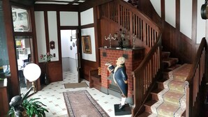A staircase with a wooden handrail and steps, leading to a landing with a mirror and a framed picture.