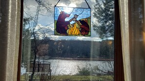 Une vitre décorée de motifs en verre coloré représentant une figure et un paysage.