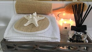 A tray with a starfish, a towel, a candle, and reed diffuser. - Serenity in the Hills - A Chic Coastal Apartment with Balcony & Ocean Glimpses (Laguna Beach)