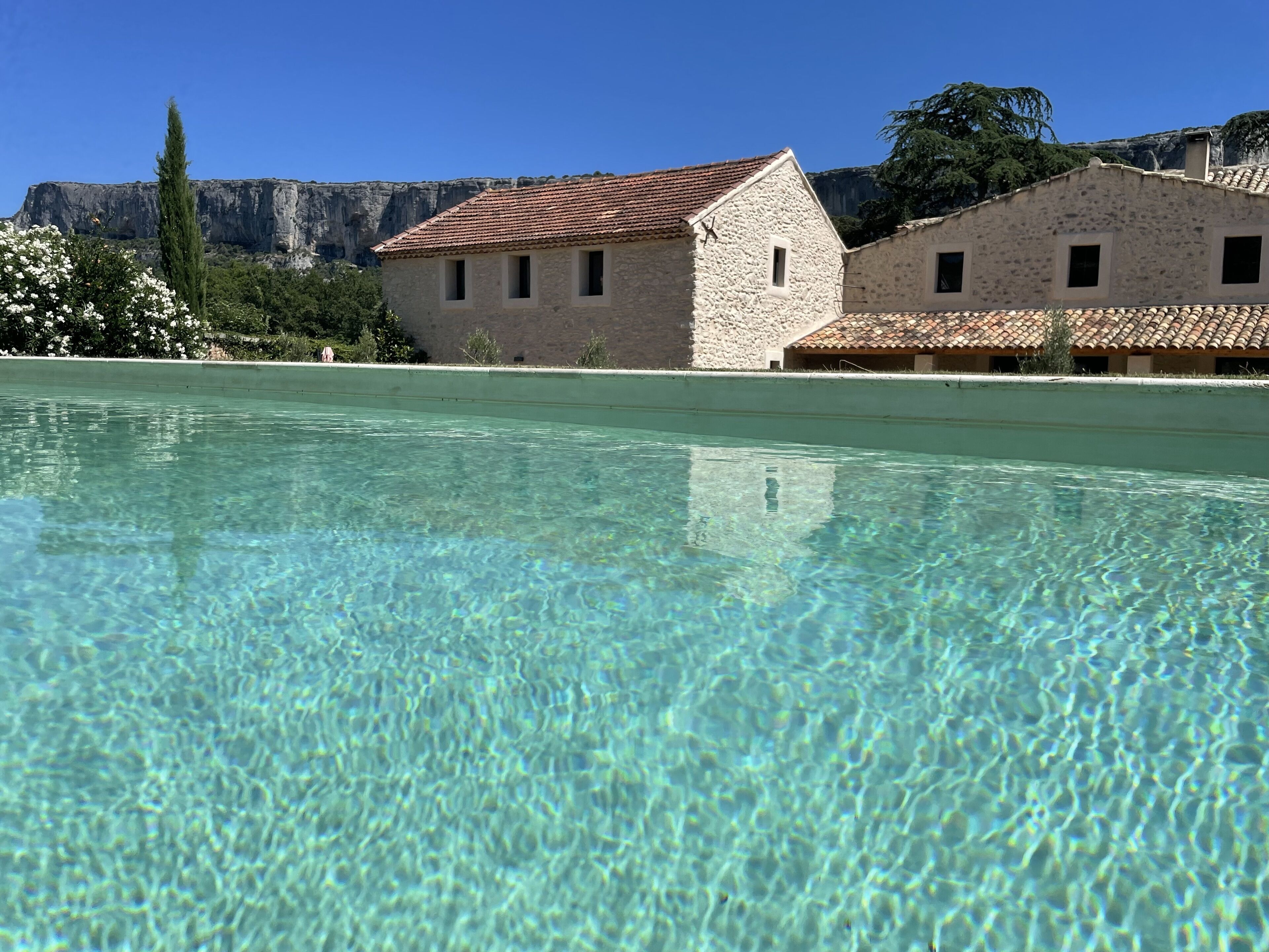 Una piscina cristalina con edificios de piedra al fondo.