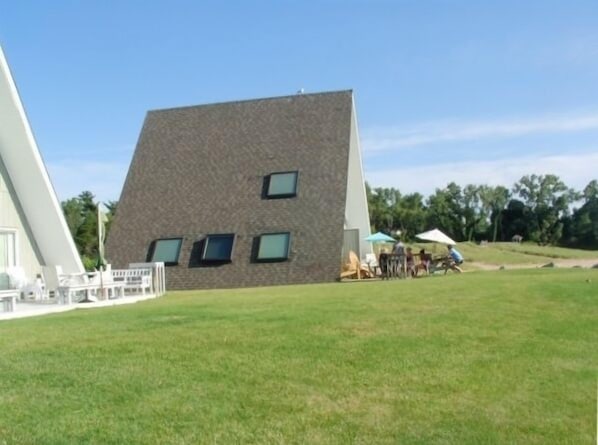 A modern building with a sloped roof and multiple windows.