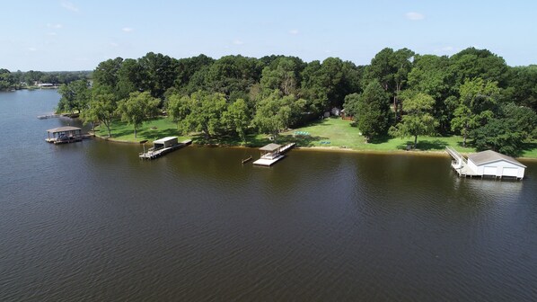 A lakeside property with a dock, a boathouse, and a covered boat storage area.