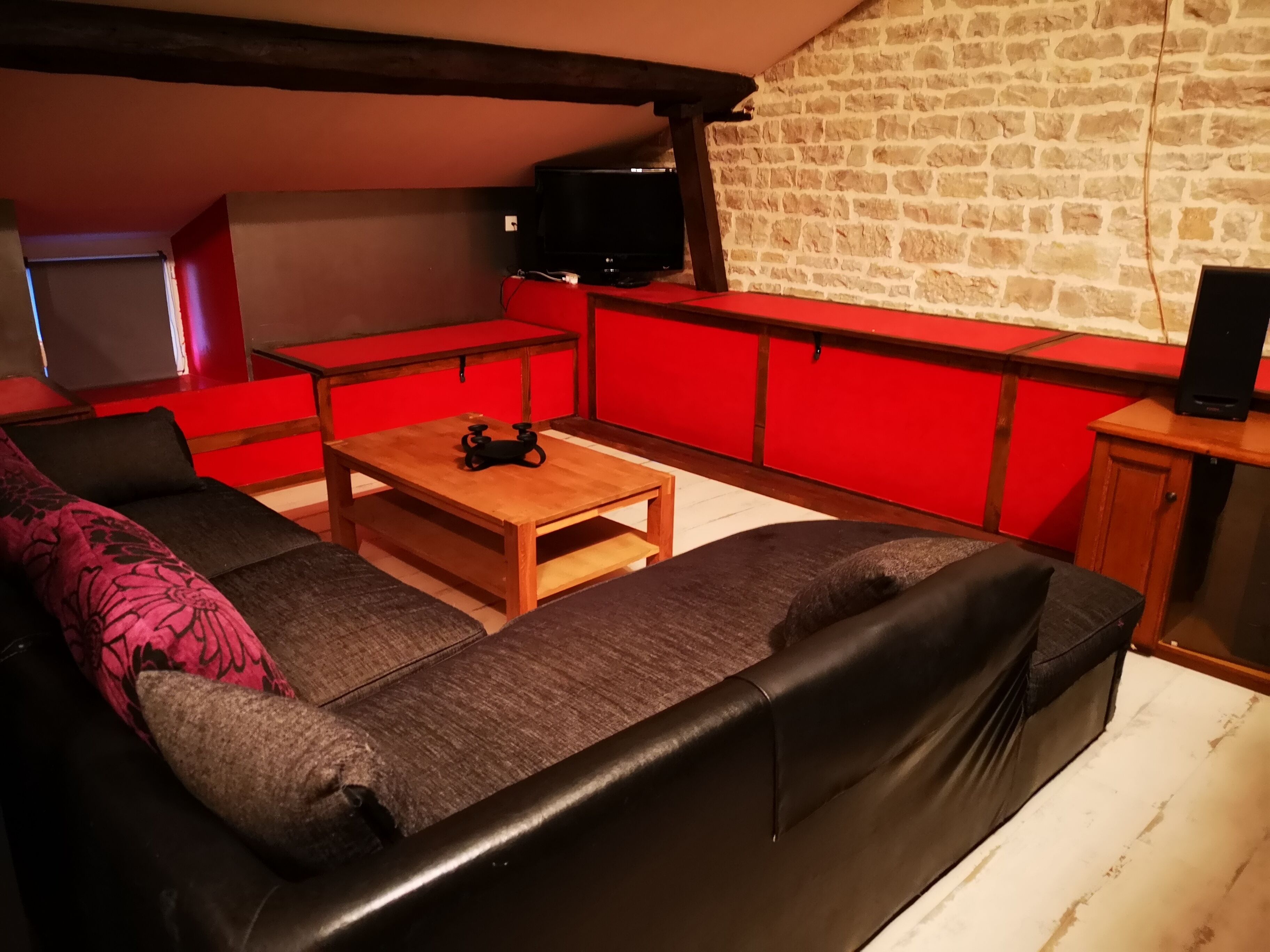 Un salon chaleureux avec un canapé, une table basse et des meubles rouges.