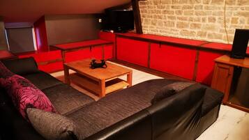 Un salon chaleureux avec un canapé, une table basse et des meubles rouges.