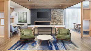 Ein modernes Wohnzimmer mit Fernseher, Sitzgelegenheiten und Kamin.