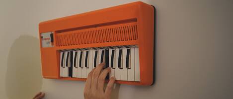 Una persona tocando un teclado naranja.
