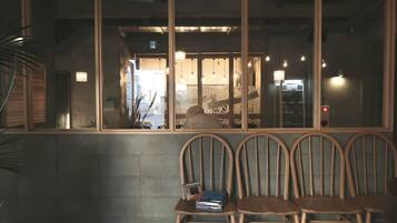 A row of wooden chairs with a stack of magazines on one.