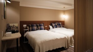 Ein Hotelzimmer mit zwei Betten, einem Nachttisch, einer Lampe und einem Wandbild.
