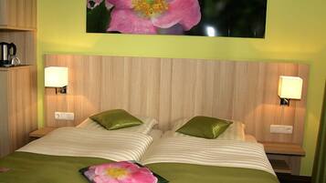 A hotel room with a bed, two bedside lamps, a nightstand, and a floral artwork on the wall.