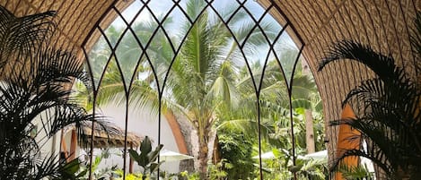 Un jardín interior con techo alto y arqueado, y un pasillo central.