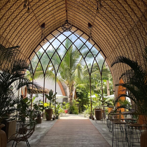 Un jardín interior con techo alto y arqueado, y un pasillo central.