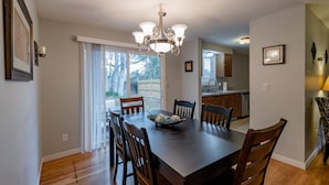A dining area with a wooden table, chairs, and a chandelier. - Minutes to Airport, Waterfront and Downtown Sleeps 6 (Bellingham)