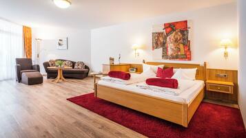 A modern hotel room with a wooden bed, red carpet, and two bedside tables with lamps.