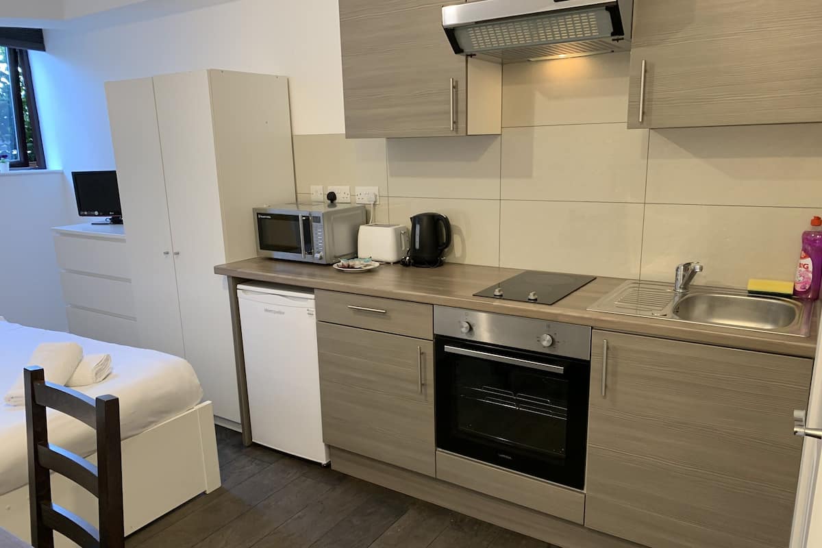 Eine kleine Küche mit Mikrowelle, Toaster, Wasserkocher und Geschirrspüler.