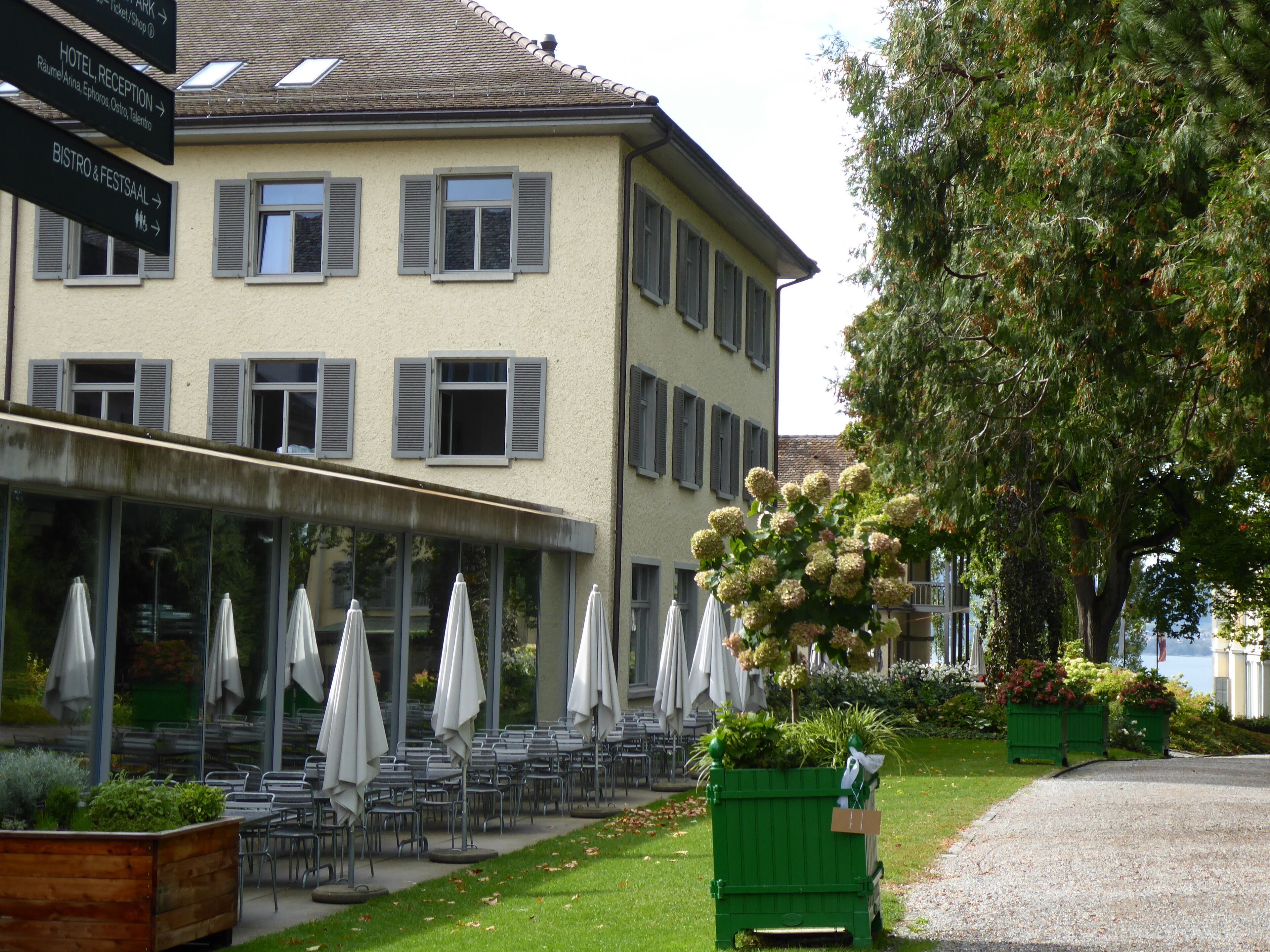 Un hotel con terraza exterior y jardín.