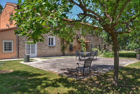 A brick building with a patio area featuring outdoor furniture.