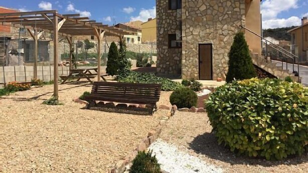 A stone building with a small porch and a wooden bench. - Rural apartment Aptos. Turísticos La Reserva for 2 people (Pajaroncillo)