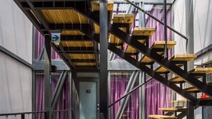 A multi-level wooden staircase with metal railings, leading to a door marked "EXIT". - Top Sunlight Inn (Liuqiu)