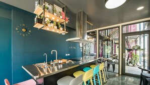 A modern kitchen with a central island, bar stools, and a visible clock. - Top Sunlight Inn (Liuqiu)