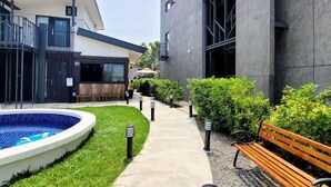 A modern building with a swimming pool, a bench, and a pathway. - Top Sunlight Inn (Liuqiu)