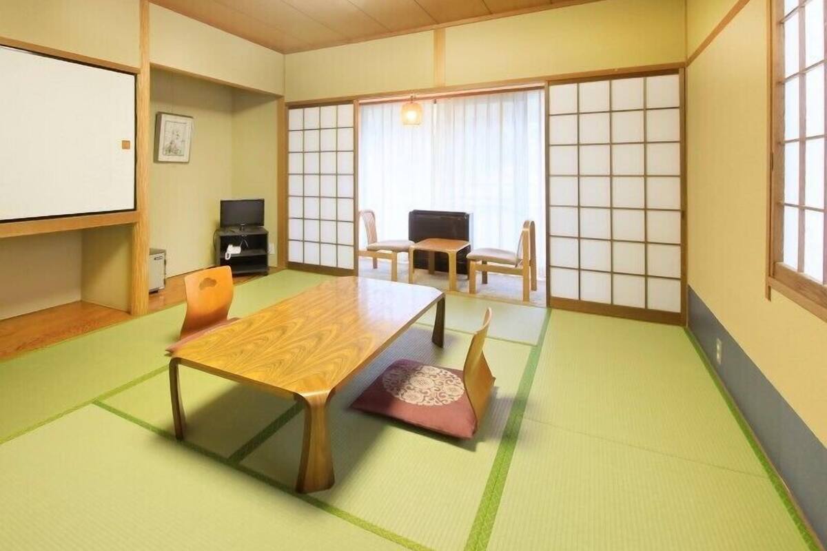 Een traditionele Japanse kamer met tatami vloeren, een lage houten tafel en schuifdeuren.