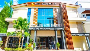 A hotel with a modern facade, featuring a large glass window and a sign for a Filipino Chinese restaurant. -  ERUS SUITES HOTEL BORACAY (Boracay Island)