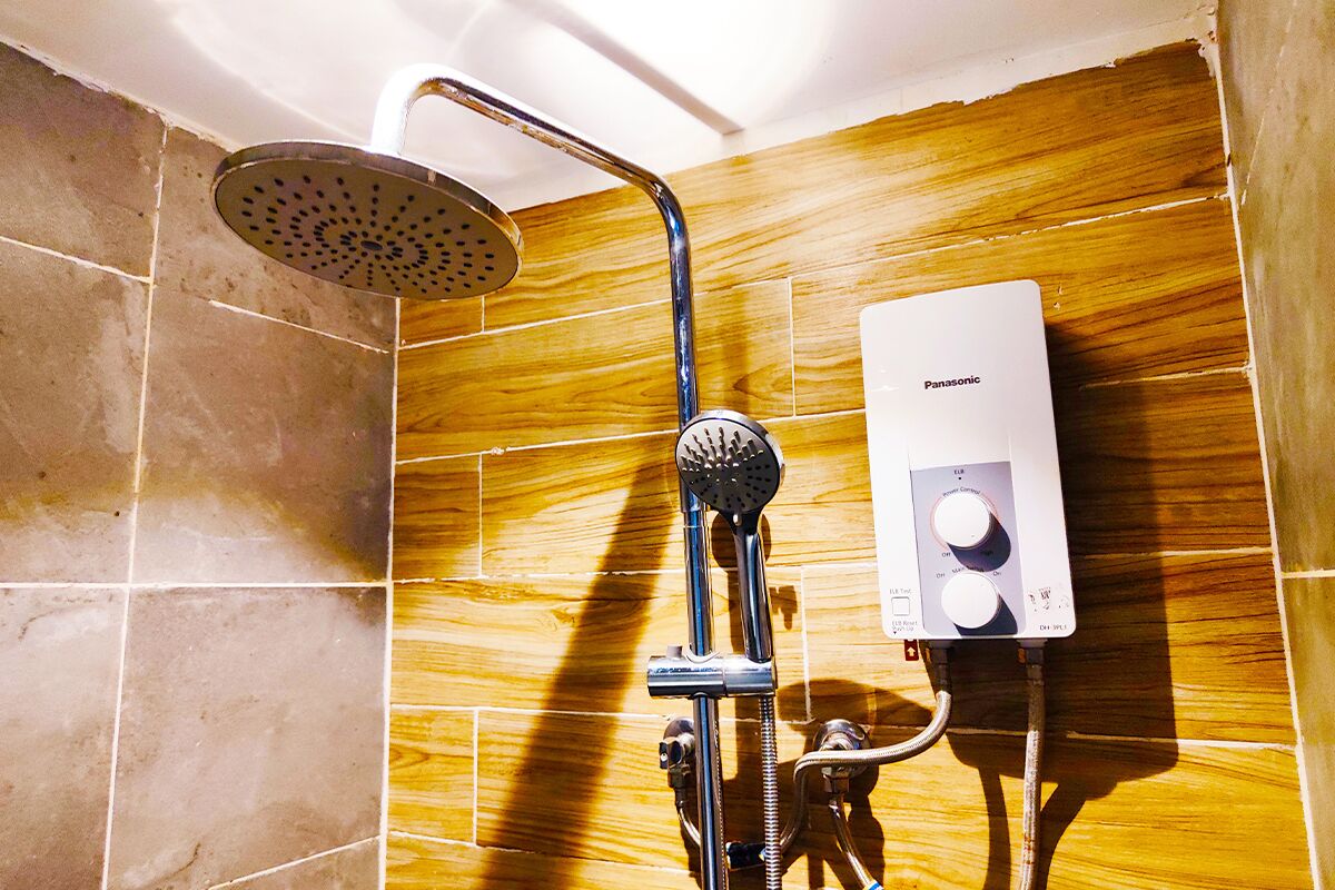A shower with a handheld showerhead and a wall-mounted control panel.