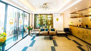 A hotel lobby with a reception desk, seating area, and a glass wall with a view. -  ERUS SUITES HOTEL BORACAY (Boracay Island)