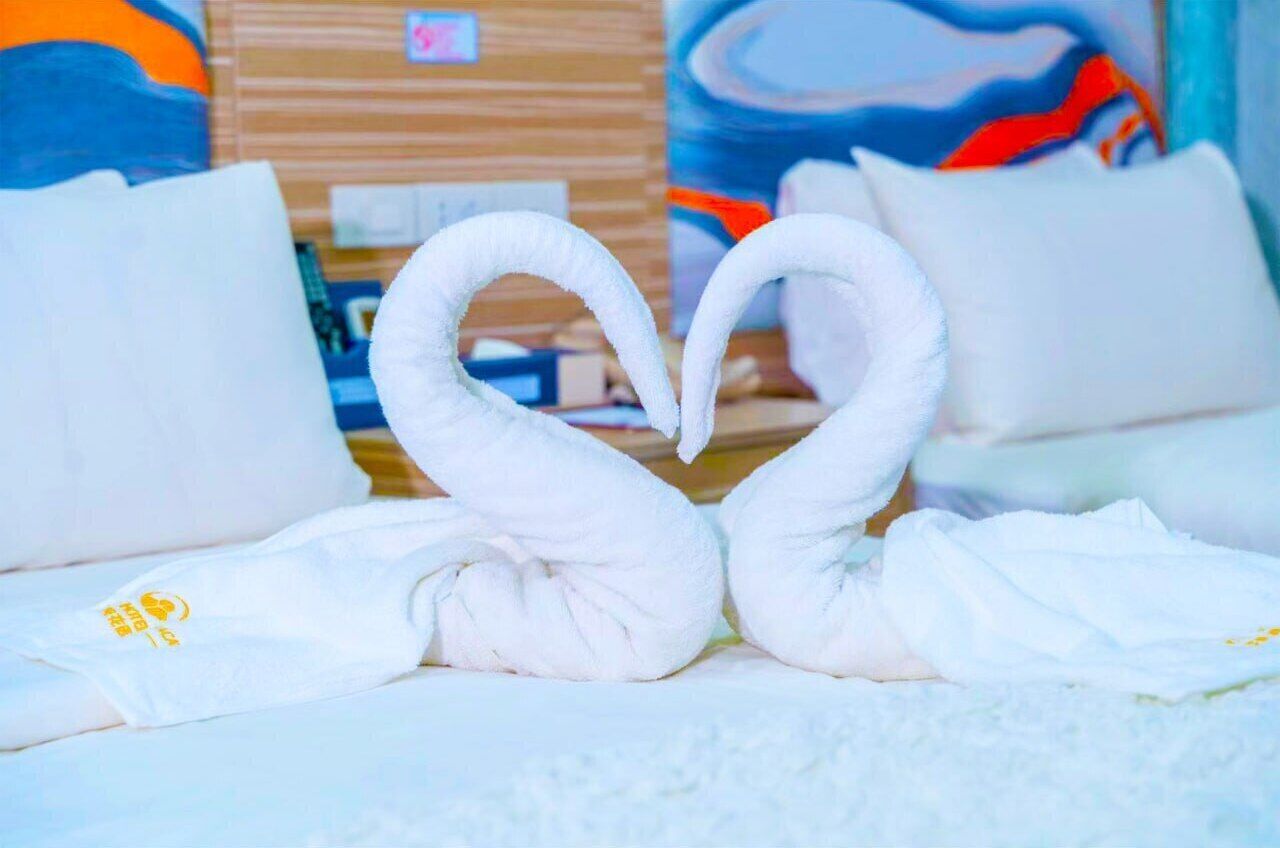 Una cama con toallas blancas dispuestas en forma de cisnes.