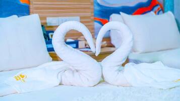 Una cama con toallas blancas dispuestas en forma de cisnes.