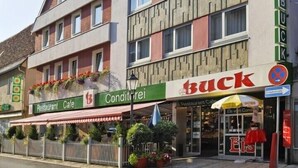 A building with a restaurant named 'Restaurant Cafe' and a store named 'Buck'. - Hotel Buck (Bad Urach)