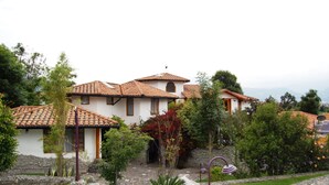 A residential property with multiple houses, a stone pathway, and a swimming pool. - House Dalia. Beautiful, cozy and independent house. Quiet in contact with nature (Tumbaco)
