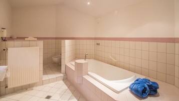 Ein modernes Badezimmer mit Badewanne, Toilette und Handtuchheizkörper.