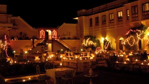 An outdoor dining area with tables and chairs, decorated with lights and plants. - Bhanwar Vilas Palace (Karauli)