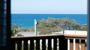 A balcony with a view of the sea, a power line, and some vegetation. - Heart of Peregian, 19 Piper Street, Peregian Beach, Noosa Area (Peregian Beach)