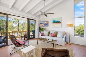 A spacious living area with a balcony, a sofa set, a coffee table, and a television. - Galleries - 1/28 Peregian Esplanade - Peregian Beach (Peregian Beach)