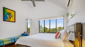 A bedroom with a bed, a bench, a window, and a painting. - Galleries - 1/28 Peregian Esplanade - Peregian Beach (Peregian Beach)