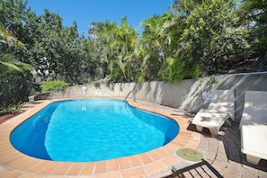 Una piscina al aire libre, sombrillas